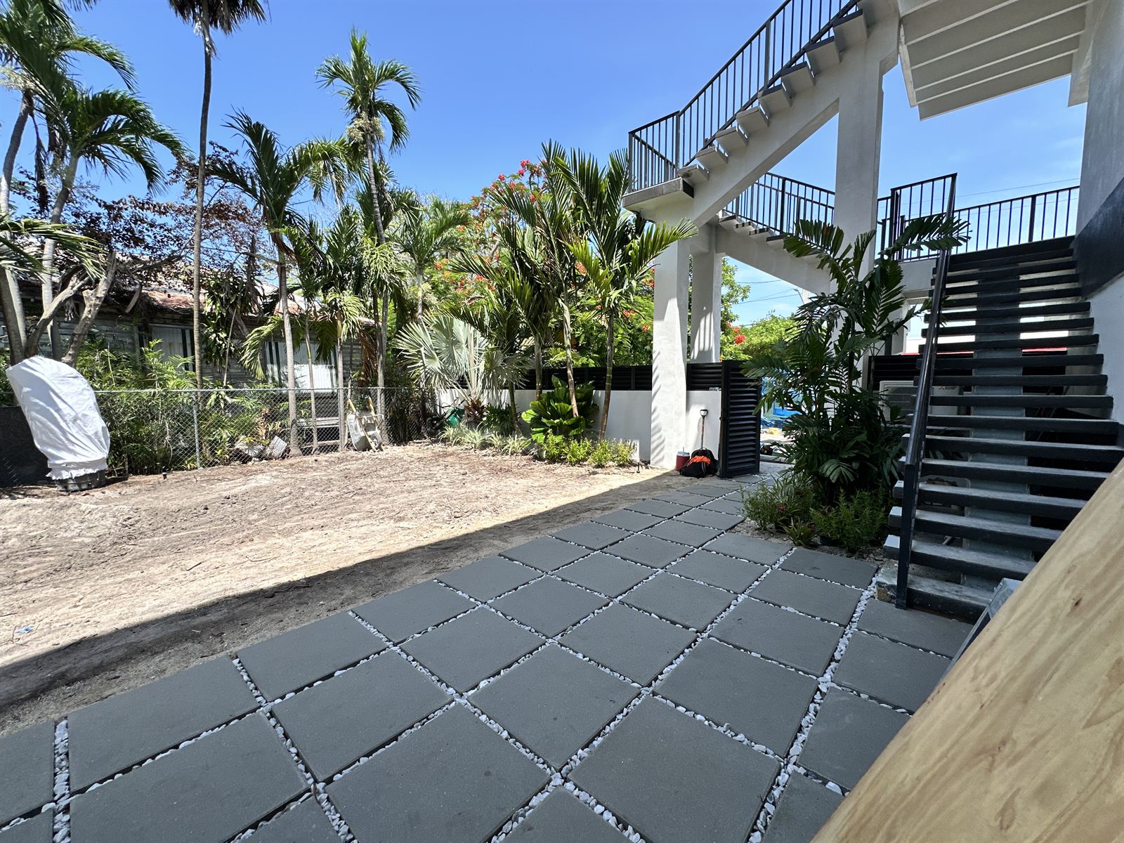 The same backyard after Garden Mountain installed a paver patio with gravel joints and fresh tropical plantings